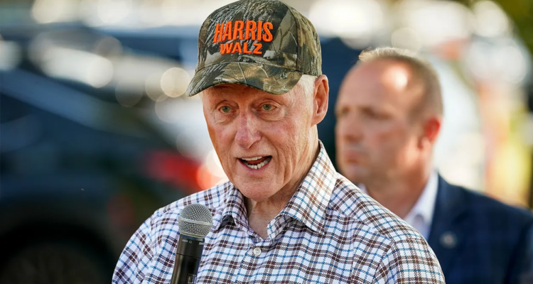 bill clinton wearing a harriz-walz camo hat